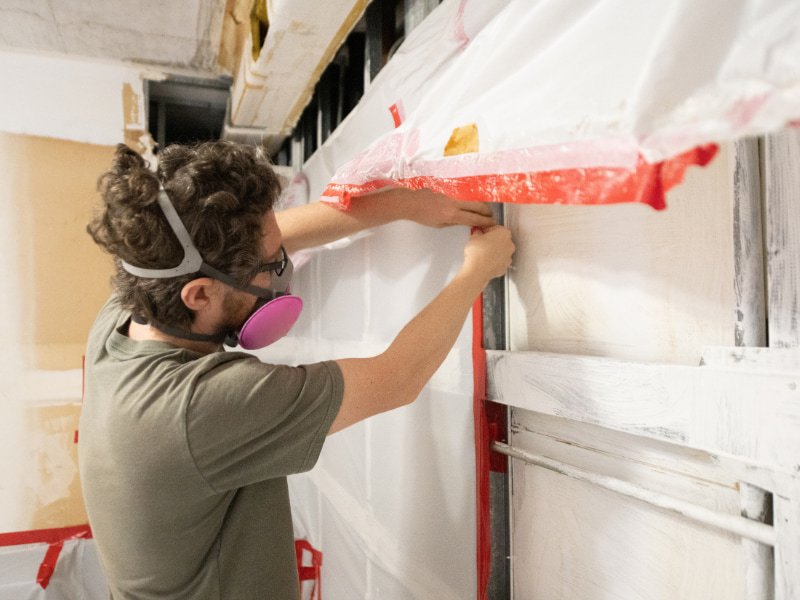 man tarping up garage mold damage